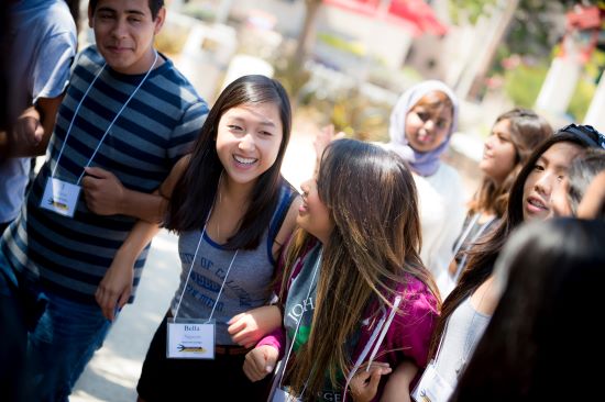 students stand holding hands and smiling